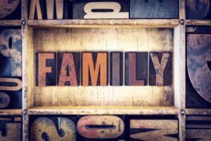 Vintage wooden type letters spelling the word "family" arranged artistically on a textured background